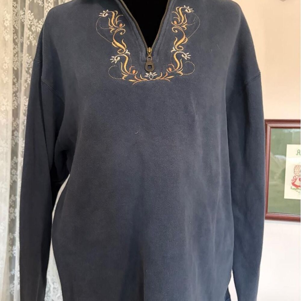 Navy blue quarter zip sweatshirt with gold embroidered floral design on the ches